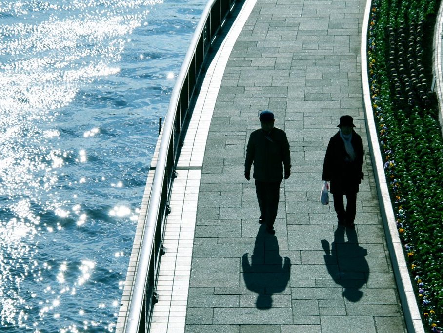 Two people walking next to canal